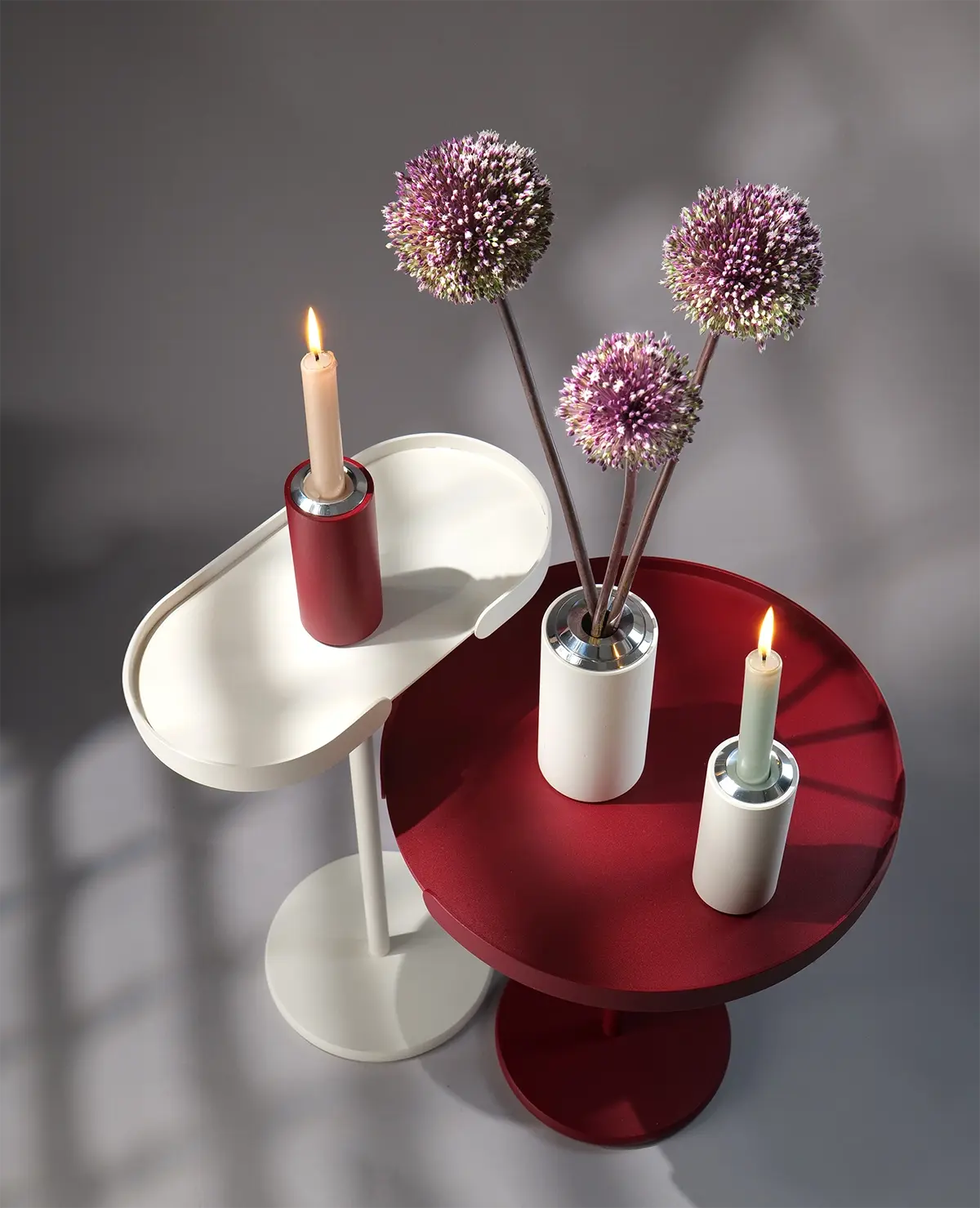 Twist Kerzenständer mit Stabkerze auf Beistelltischen Stan und Ollie – elegant und reduziert