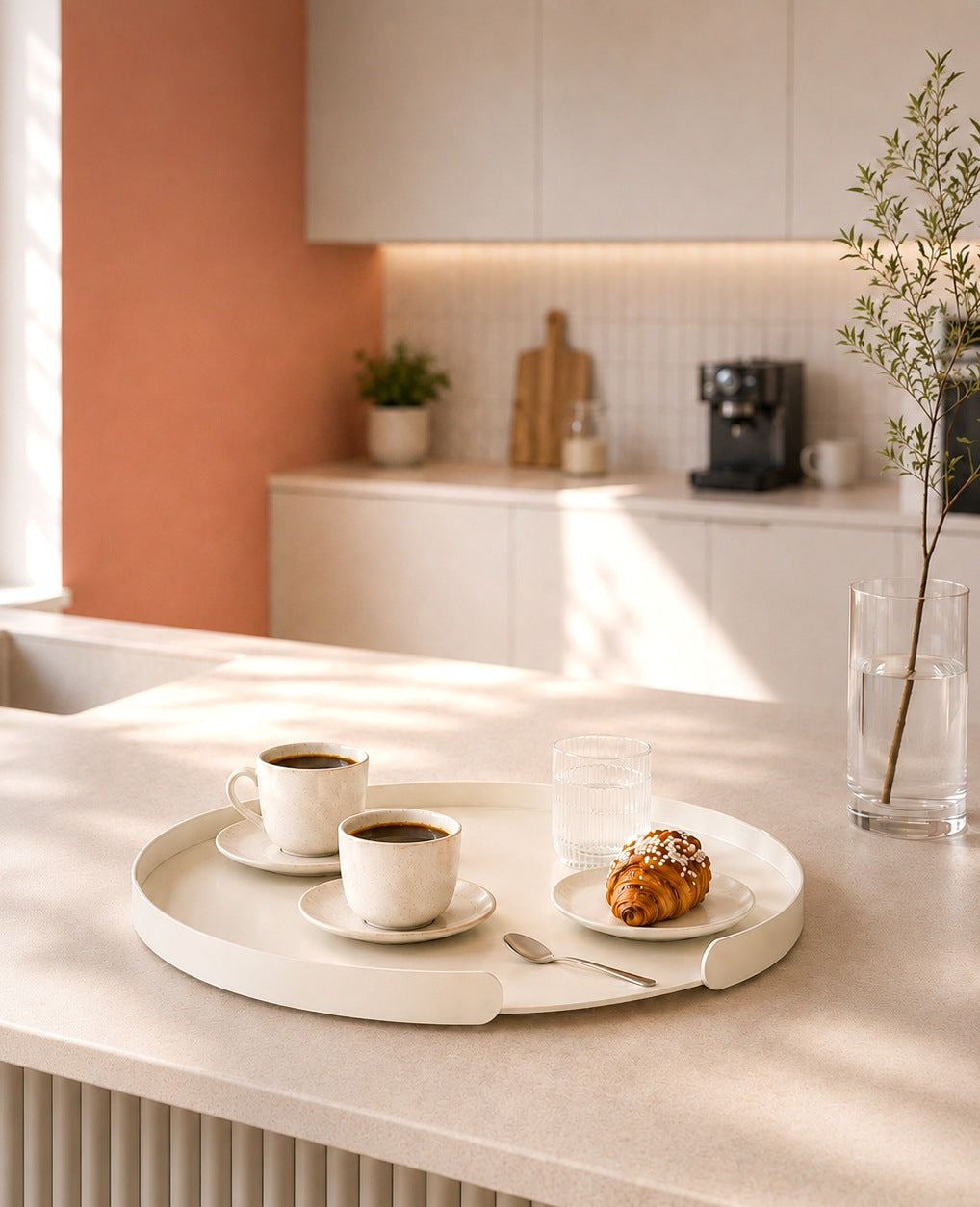Helles Tablett aus Metall mit Kaffee und Gebäck auf einem Esstisch in der Küche