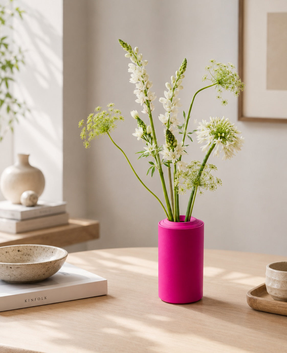 Pinke Vase aus Metall als farbiger Akzent in einem hellen Wohnraum