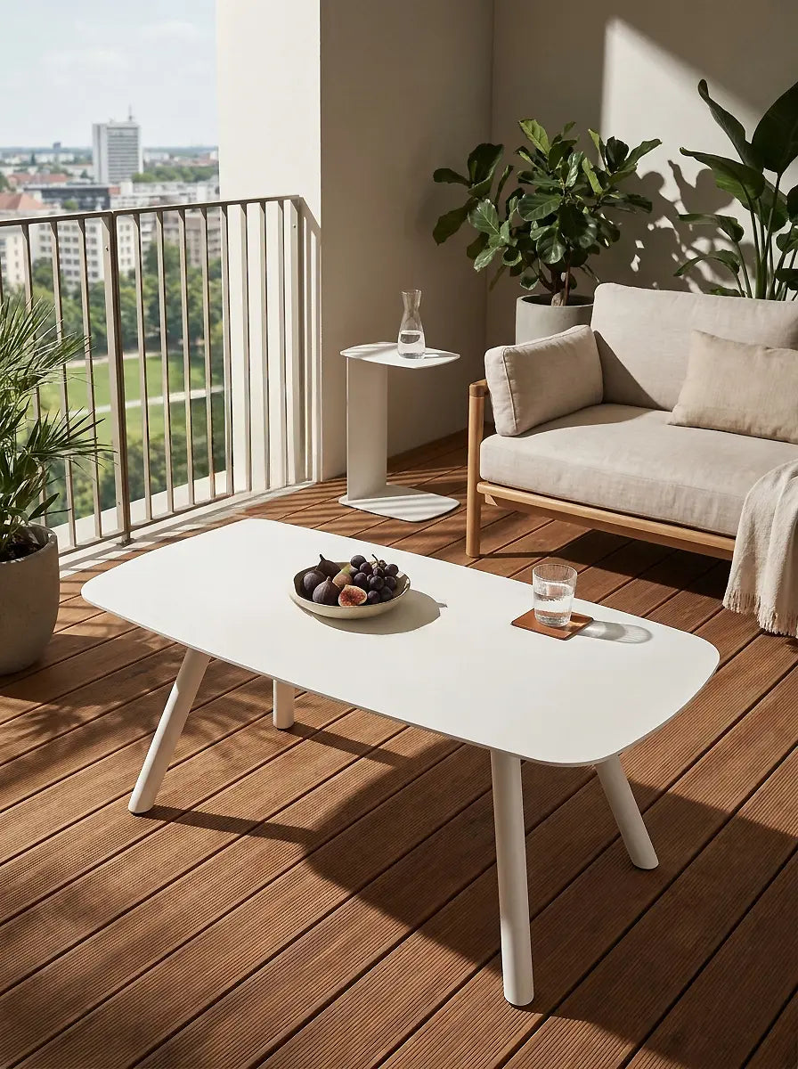 Forma Couchtisch aus Metall vor einem Sofa im modernen Outdoor-Wohnzimmer mit charakteristischer Kontur und matt pulverbeschichteter Oberfläche.