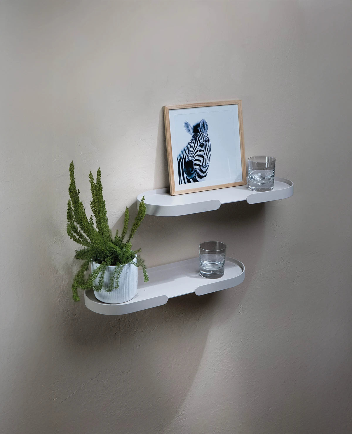 Zwei versetzt angeordnete MONDO Shelf Wandregale aus Aluminium, dekoriert mit Bildern, Gläsern, Pflanzen und kleinen Objekten, modernes Wandregal für Wohnzimmer oder Arbeitszimmer, funktional und elegant zugleich.