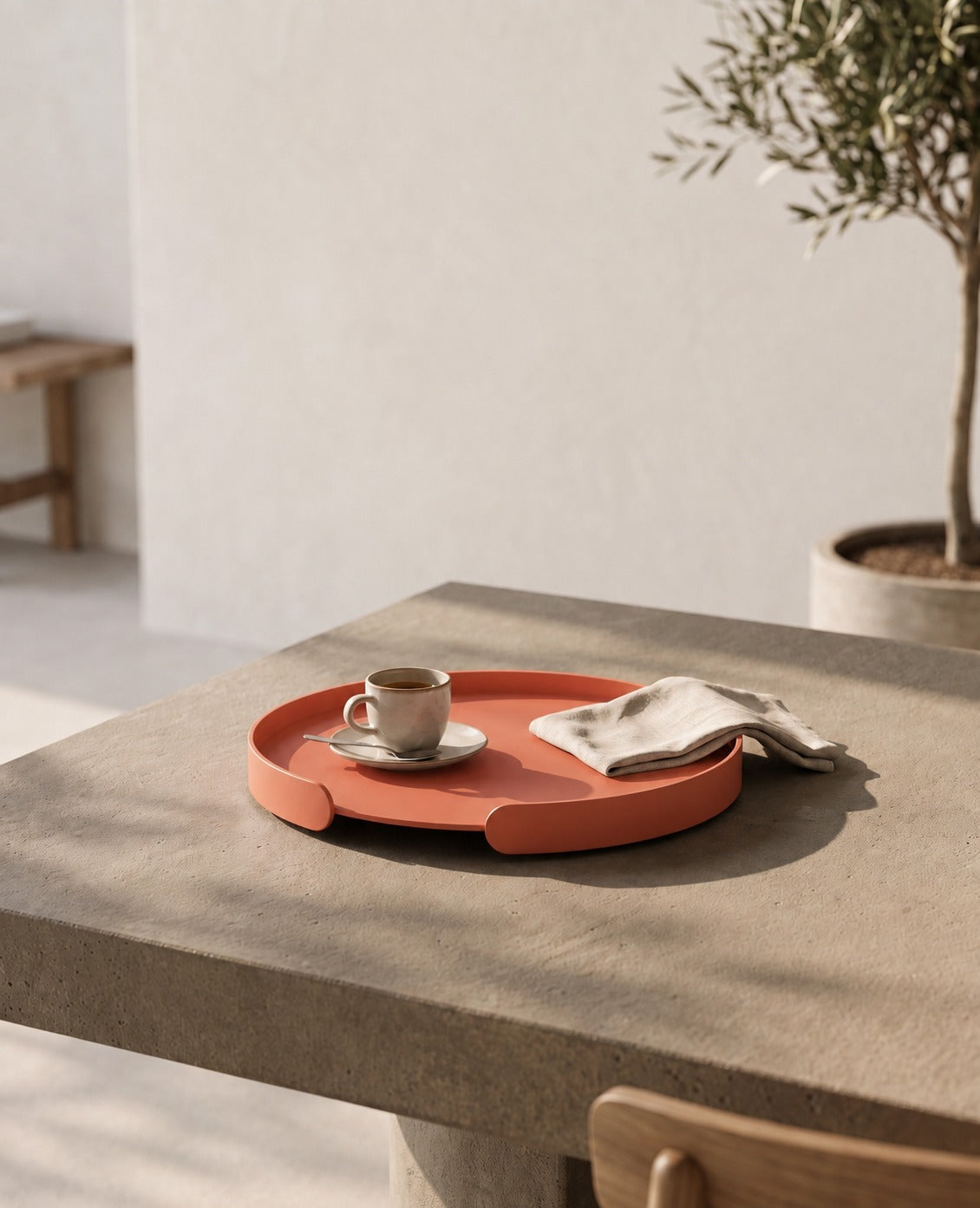 Lachsoranges Metalltablett Milo von Siqual Design auf hellem Steintisch mit Espressotasse und Leinentuch in warmer Outdoor-Atmosphäre.