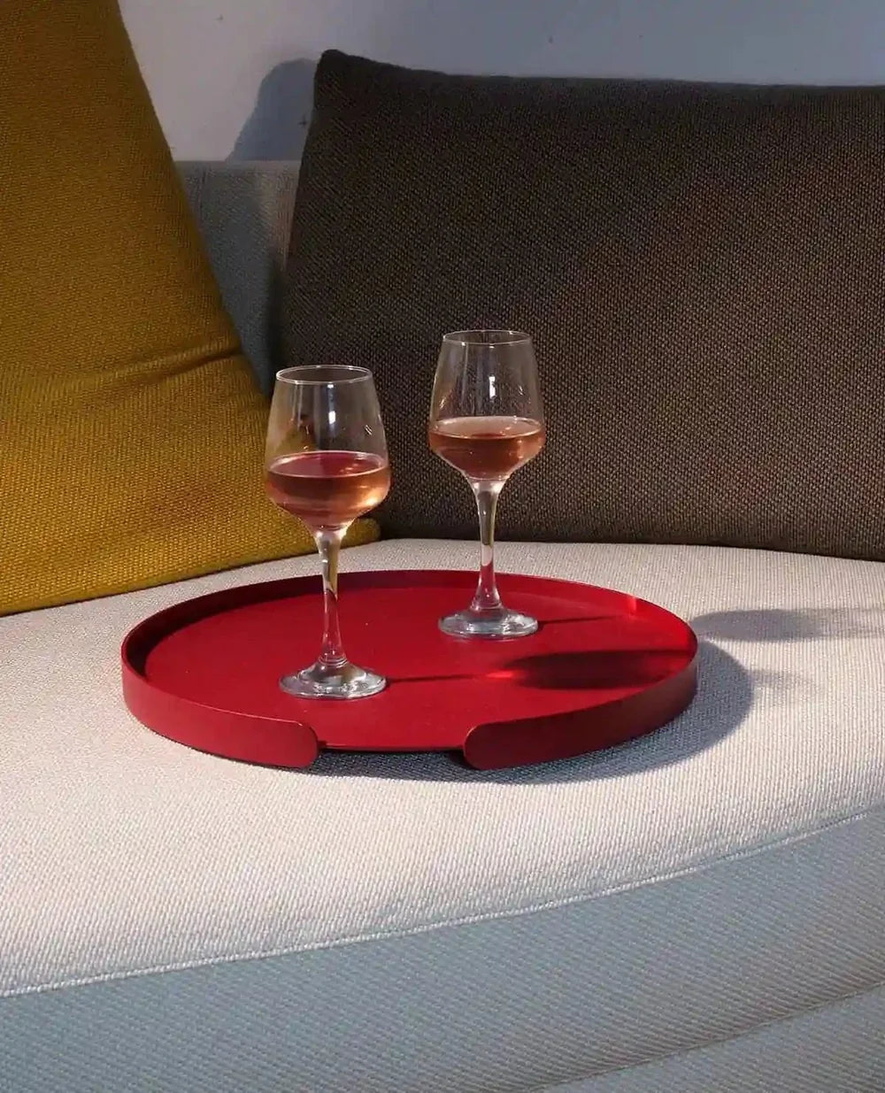 Rotes Metalltablett Lilo auf dem Sofa – komfortable Nutzung als Ablage im Wohnbereich