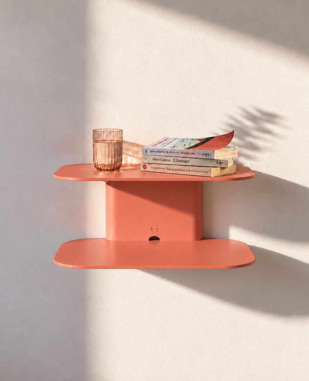 ARCO Wandkonsole aus Metall in Lachsorange mit Büchern und Accessoires – farbige Design-Wandkonsole für den Wohnbereich.