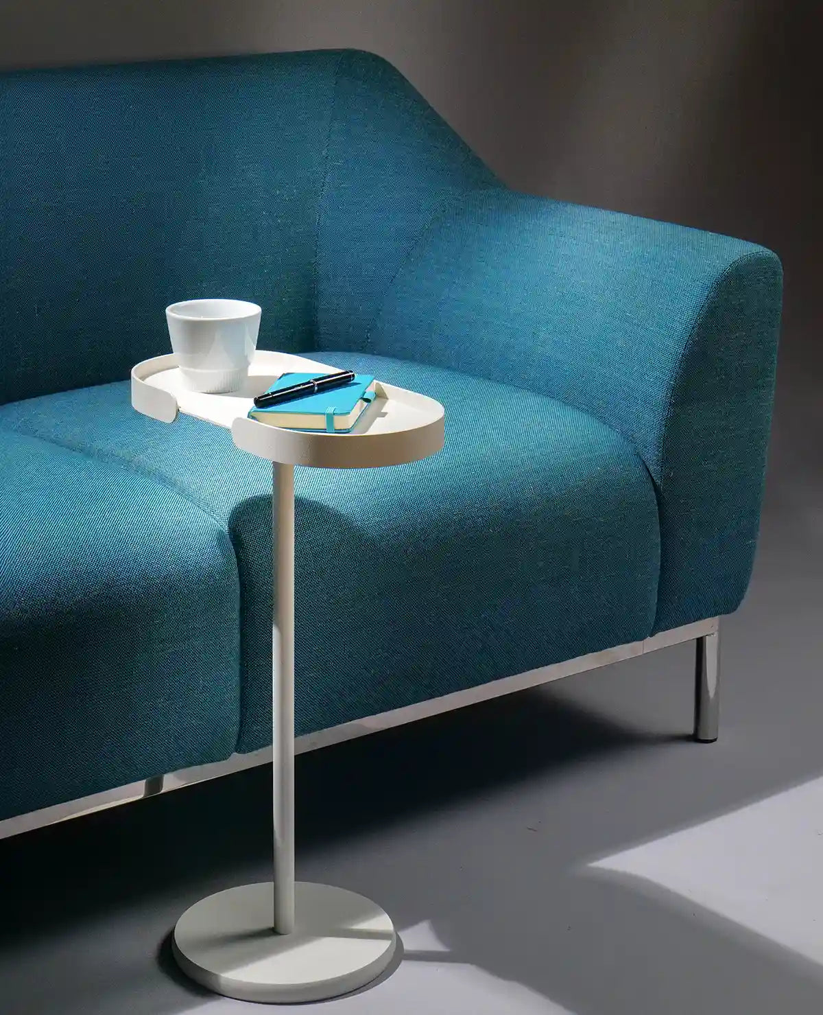 Cremeweißer Beistelltisch Stan als praktische Ablage mit Kaffeetasse und Buch – alltägliche Nutzung
