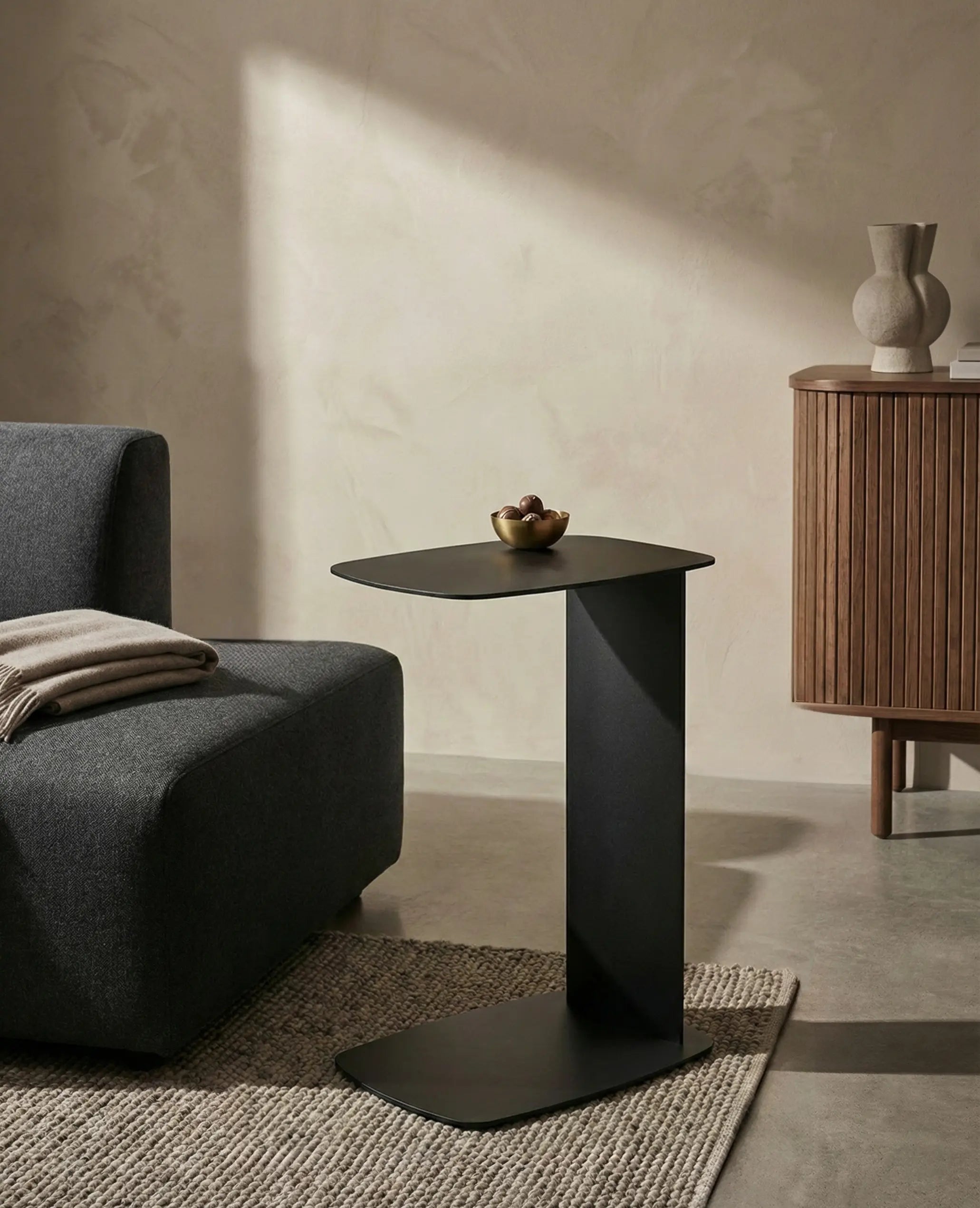 C-förmiger Beistelltisch STANDBY aus Aluminium in Schwarz von Siqual Design am Sofa im modernen Wohnzimmer