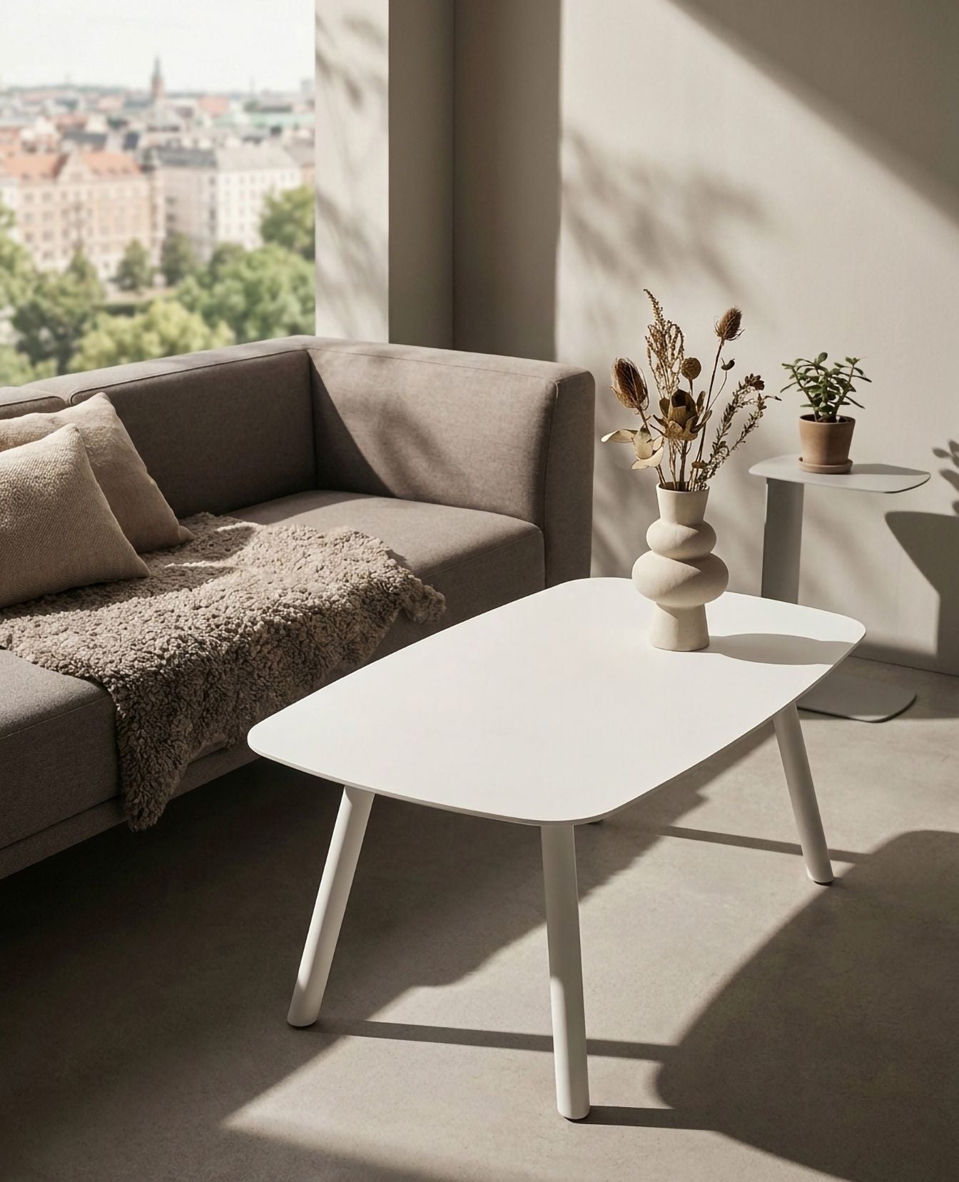 FORMA Couchtisch aus Metall von Siqual Design vor Sofa im hellen Wohnzimmer mit natürlichem Licht