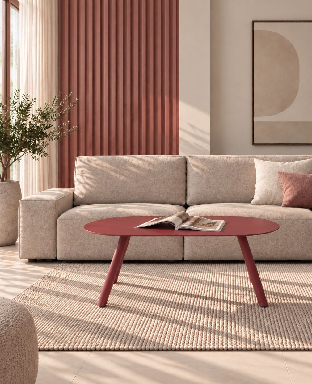 Ovaler Design-Couchtisch OLIVIO aus Metall in Purpurrot mit Magazin, vor einem beigen Sofa auf strukturiertem Teppich in einem modernen Wohnzimmer.