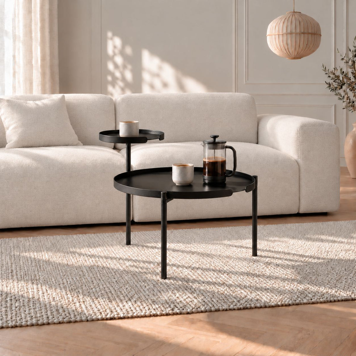 ORBIS PLUS Couchtisch aus Metall in Schwarz mit zwei Ablageflächen vor dem Sofa im Wohnzimmer