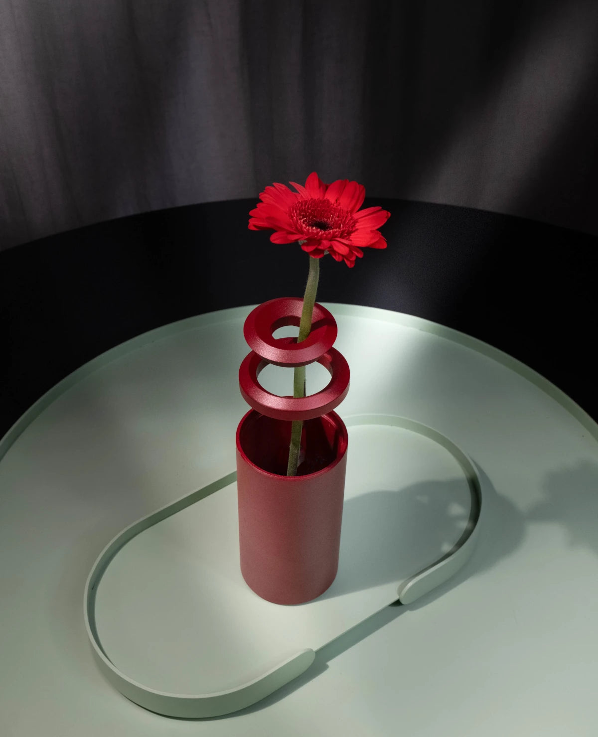 Rote Vase mit roter Blume und Aluminiumringen