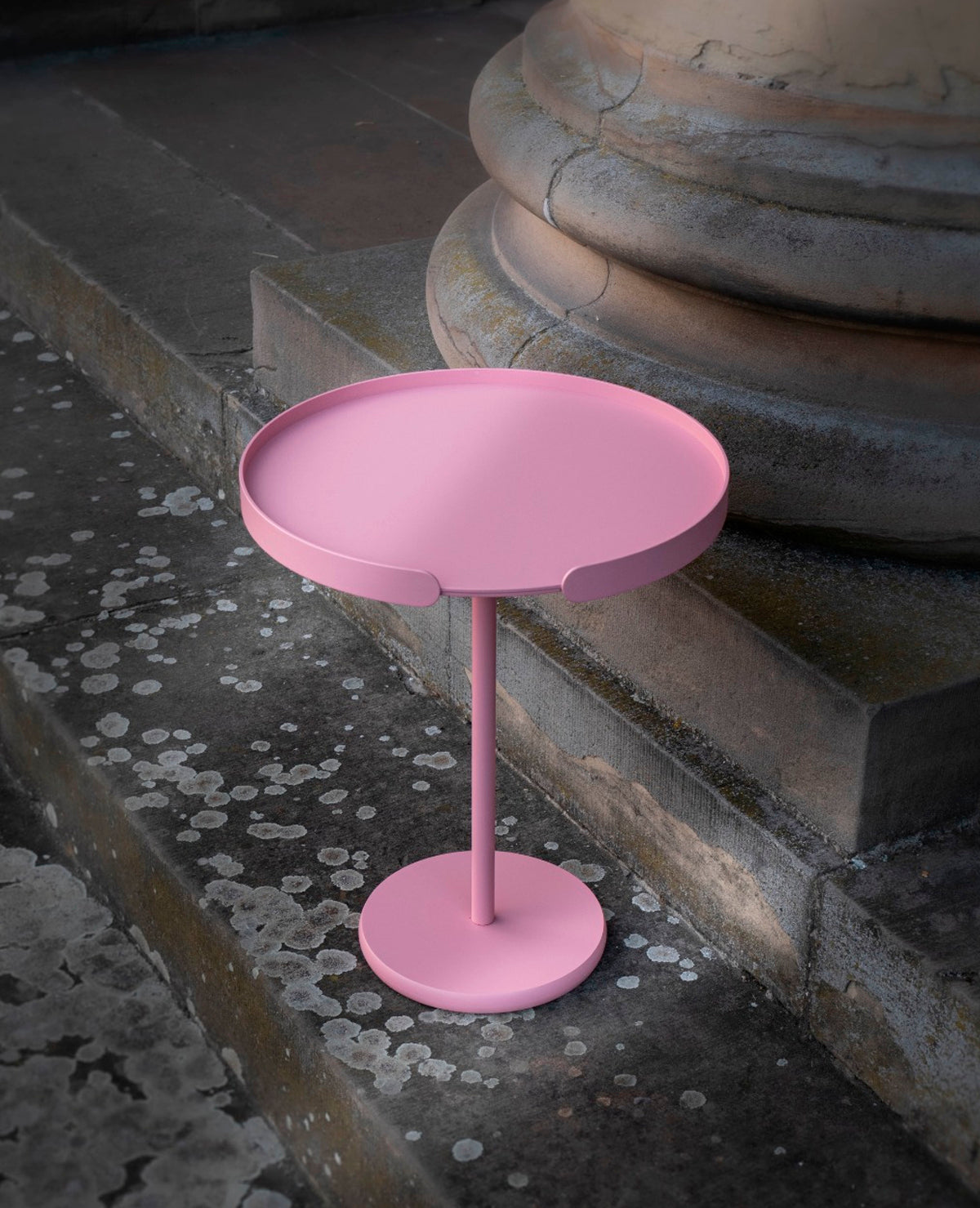 OLLIE Beistelltisch aus Metall in Flamingo Rosa mit abnehmbarem Tablett im Outdoor-Bereich vor Natursteinarchitektur