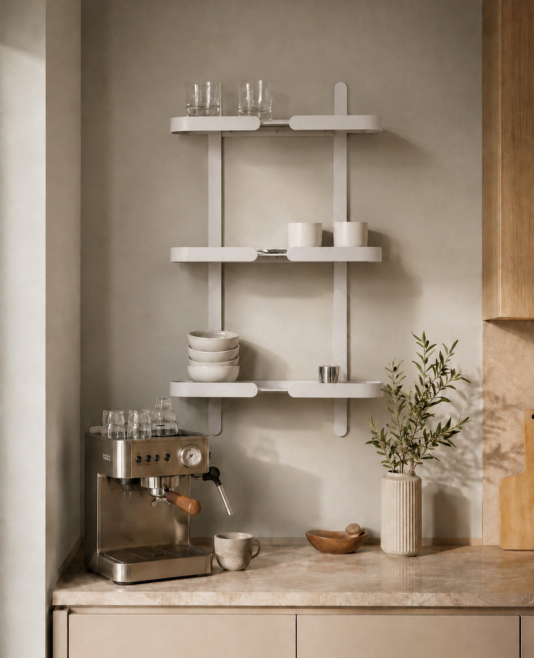 Weißes Siqual Design Wandregal aus Metall als stilvolle Kaffeebar in heller Küche mit Espressomaschine, Tassen und Keramikgeschirr.